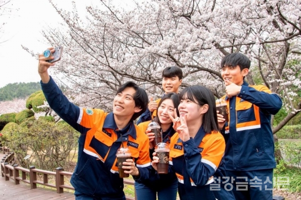 광양제철소 직원들이 벚꽃을 배경으로 함께 기념사진을 촬영하고 있다. 포스코 제공.