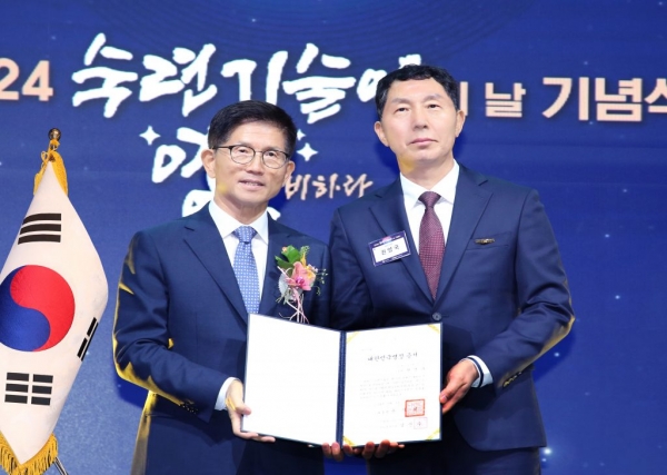 권영국 포스코명장(오른쪽)이 김문수 고용노동부장관으로부터 대한민국명장 증서를 받고 기념 촬영을 하고 있다. 포스코 제공.