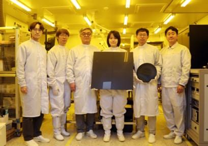 한국기계연구원 자율제조연구소 반도체장비연구센터 송준엽 연구위원 연구팀(왼쪽부터 오승진 선임연구원, 이재학 책임연구원, 송준엽 연구위원, 박아영 선임연구원, 문현규 선임연구원, 한성흠 책임연구원). 개발한 대면적 사각형 패널과 기존의 원형 웨이퍼를 비교하여 들고 있다. (사진=기계연구원)