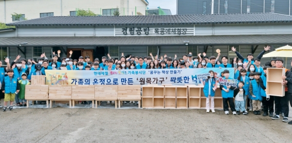 현대제철 해피프리즘 가족봉사단이 지난 24일 순성면 소재 목공예 공방에서 목공가구 제작 활동에 앞서 기념촬영을 하고 있다. /현대제철