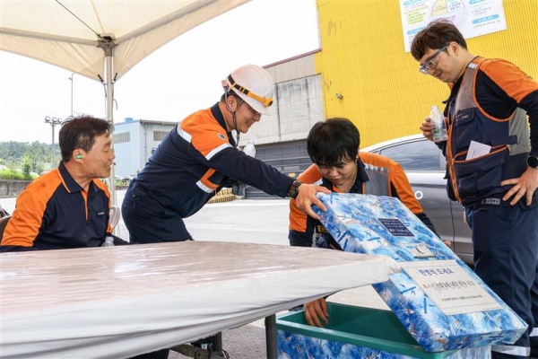 포스코 포항제철소 직원들이 그늘막 아래에서 물을 꺼내고 있다. /포스코
