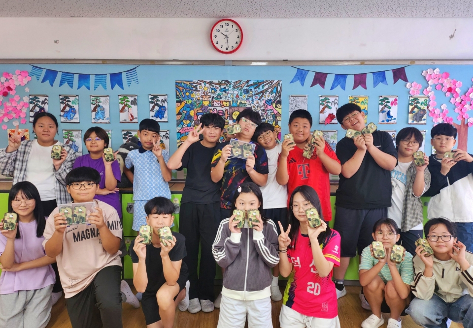 울산 덕신초 주니어 공학교실 특별수업에서 학생들이 직접 만든 무전기를 자랑하며 환하게 웃고 있다. (사진=고려아연)