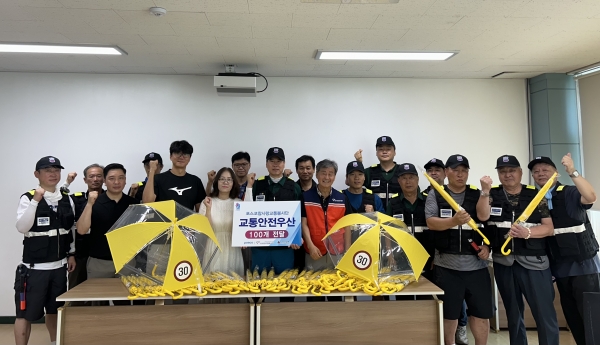 포스코 포항제철소 참사랑교통봉사단과 (사)포항시자원봉사센터 관계자들이 9일 포항시 송도초등학교에서 교통지도 봉사활동을 실시한 뒤 교통안전우산을 전달하고 기념촬영을 하고 있다.